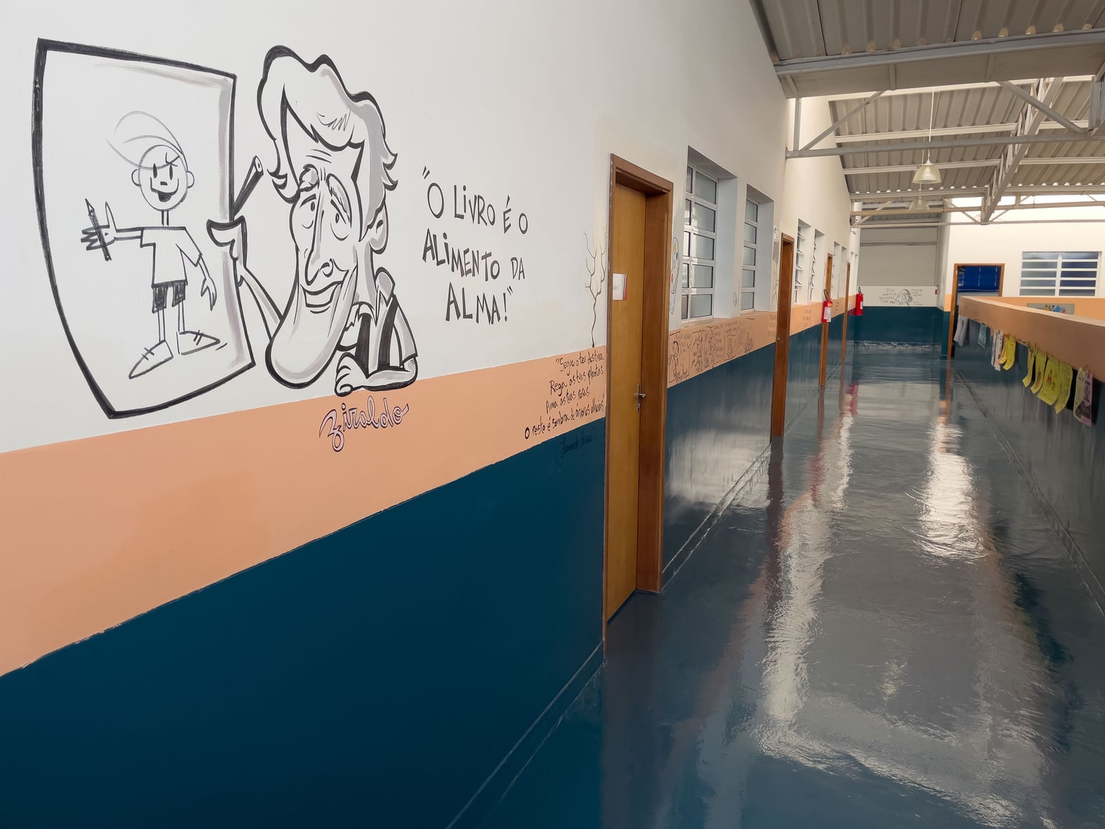 Corredor com portas das salas e mural da unidade