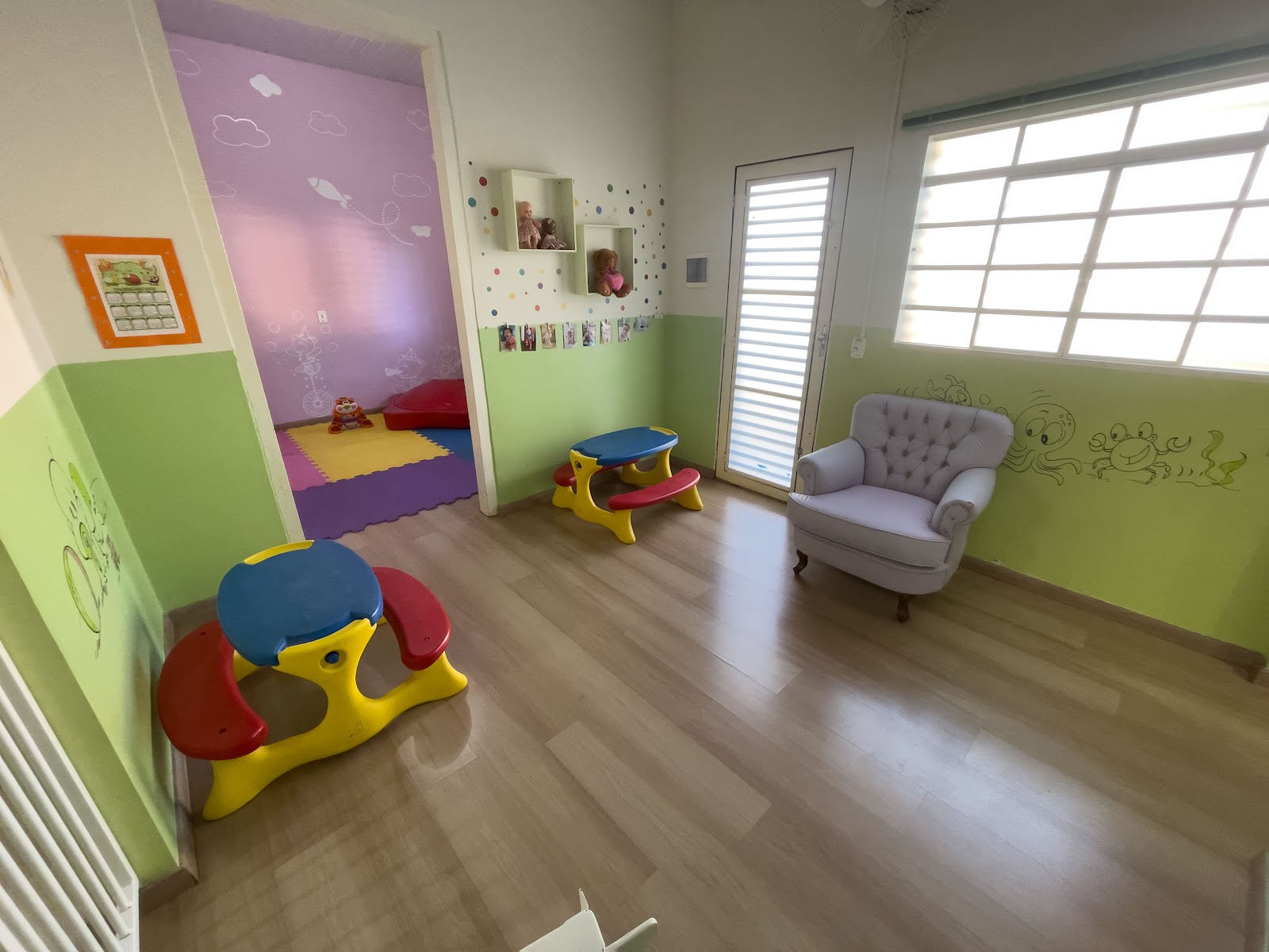 Sala de acolhimento do Berçário com brinquedos e poltronas