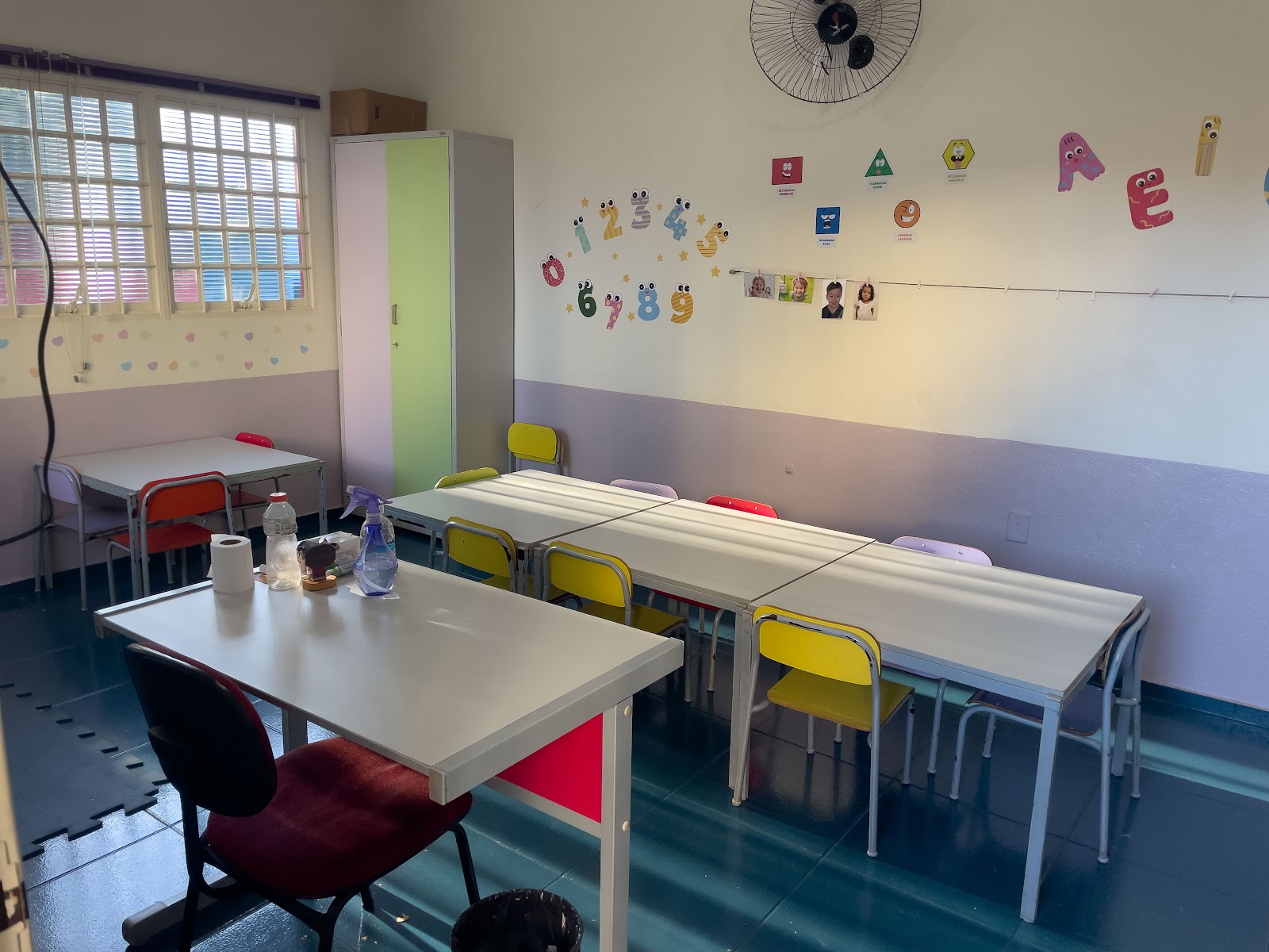 Sala de aula com mesas e cadeiras da Educação Infantil