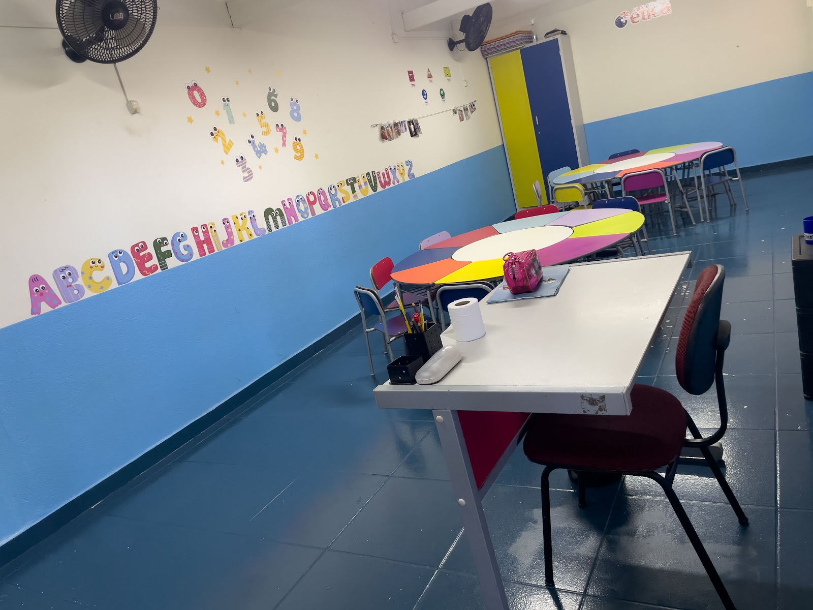 Mesa e materiais de uma sala de aula da Educação Infantil