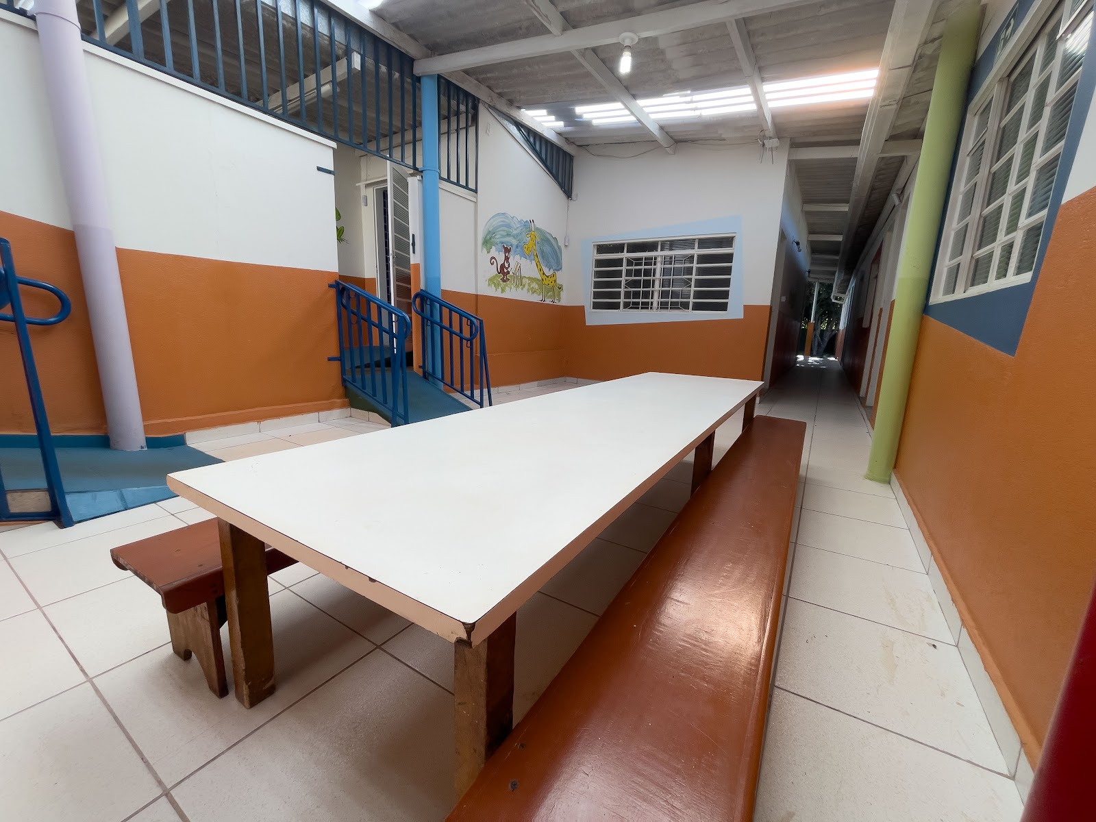 Área coberta com mesas para atividades em grupo